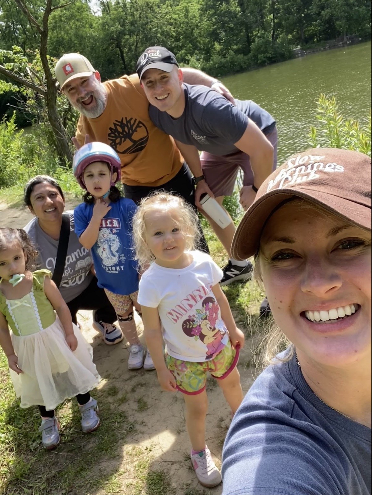 A crowded selfie by a lake with friends and their kids
